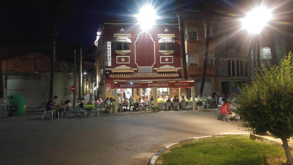 阿尔卡拉德克西韦尔特Hostal Rosaleda的一群人晚上坐在餐厅外面