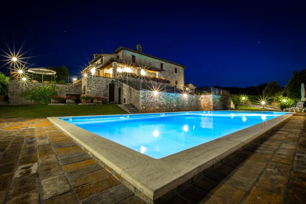 MercatelloTorre Piantarosa的夜间在房子前面的游泳池