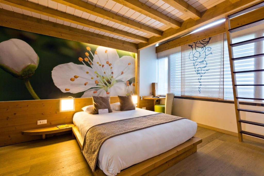 雷加霍斯达哈施萨沃伊拉克罗伊克斯&Spa酒店的卧室配有一张大床,墙上挂有花卉画