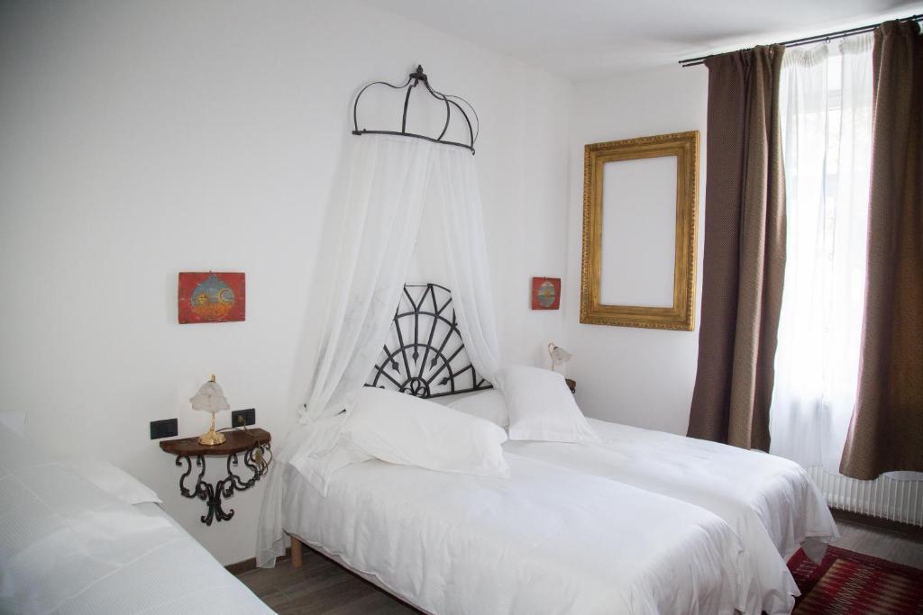 特伦托B&B La Loggia Del Castello的一间卧室设有两张白色的床和窗户