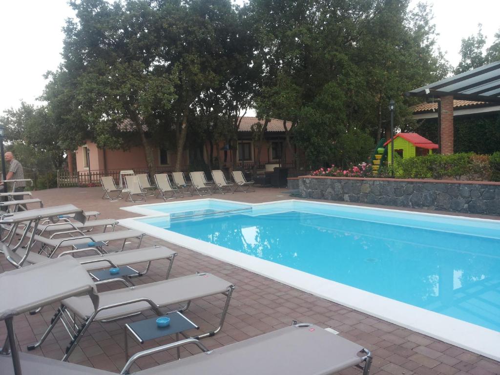 扎费拉纳-埃特内阿Poggiofelice B&B的一个带桌椅的游泳池和一个游乐场