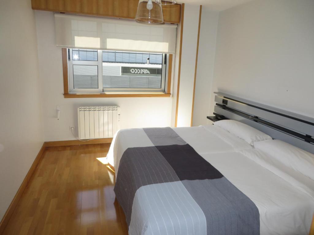 拉科鲁尼亚Toctoc Rooms的一间卧室设有一张大床和窗户
