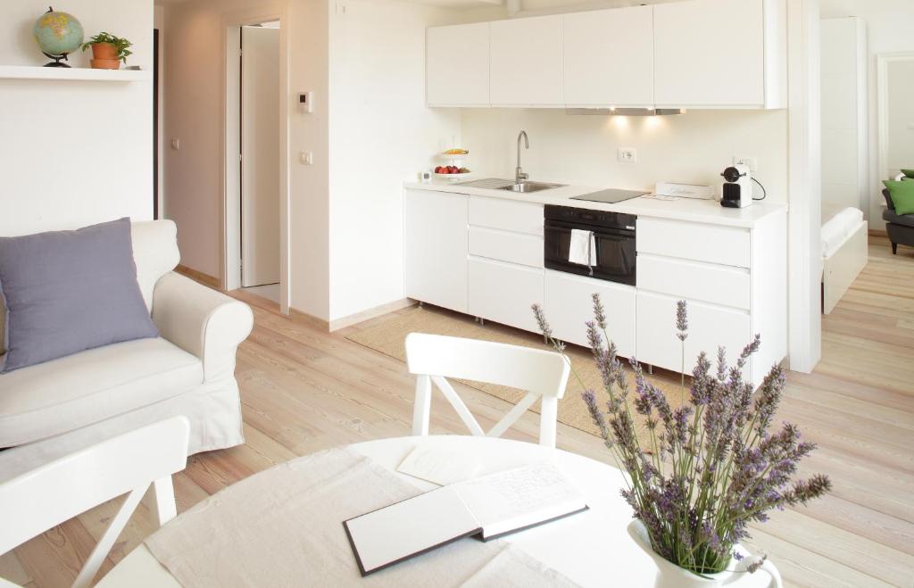 米拉The Riverside Suite的白色的厨房以及带沙发和桌子的客厅。