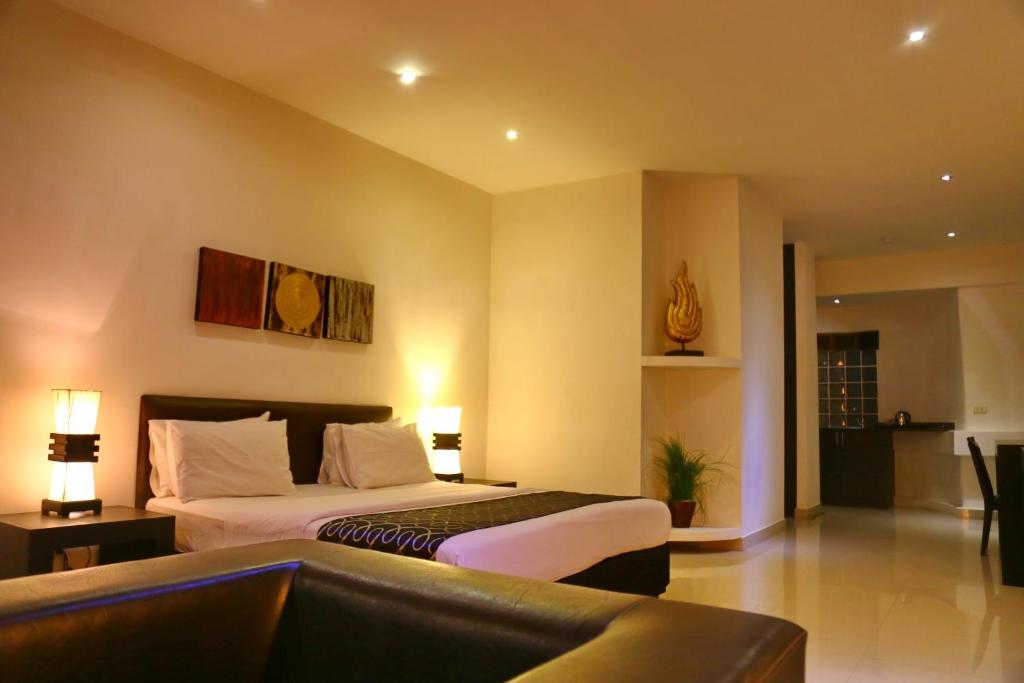 南芭堤雅东方套房酒店的酒店客房,配有床和沙发