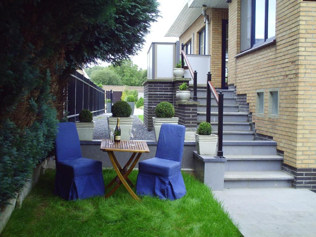 尼诺纲卡皮塔尔公寓的庭院设有2把蓝色椅子、桌子和楼梯