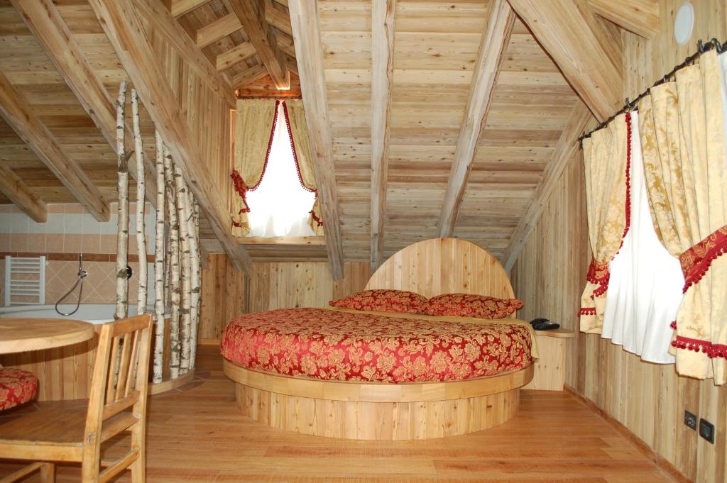 TerzolasResidenza La Corte Dei Toldi的一间带一张床的卧室,位于带木制天花板的房间内
