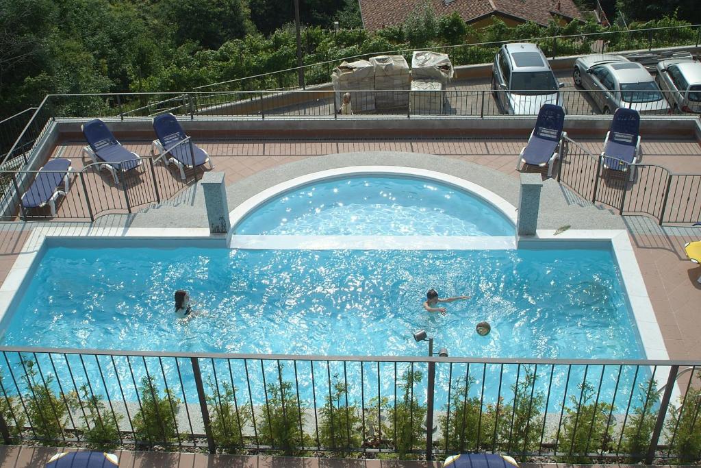 奥杰比奥Residence Il Vigneto的一个游泳池,有三人在里面游泳