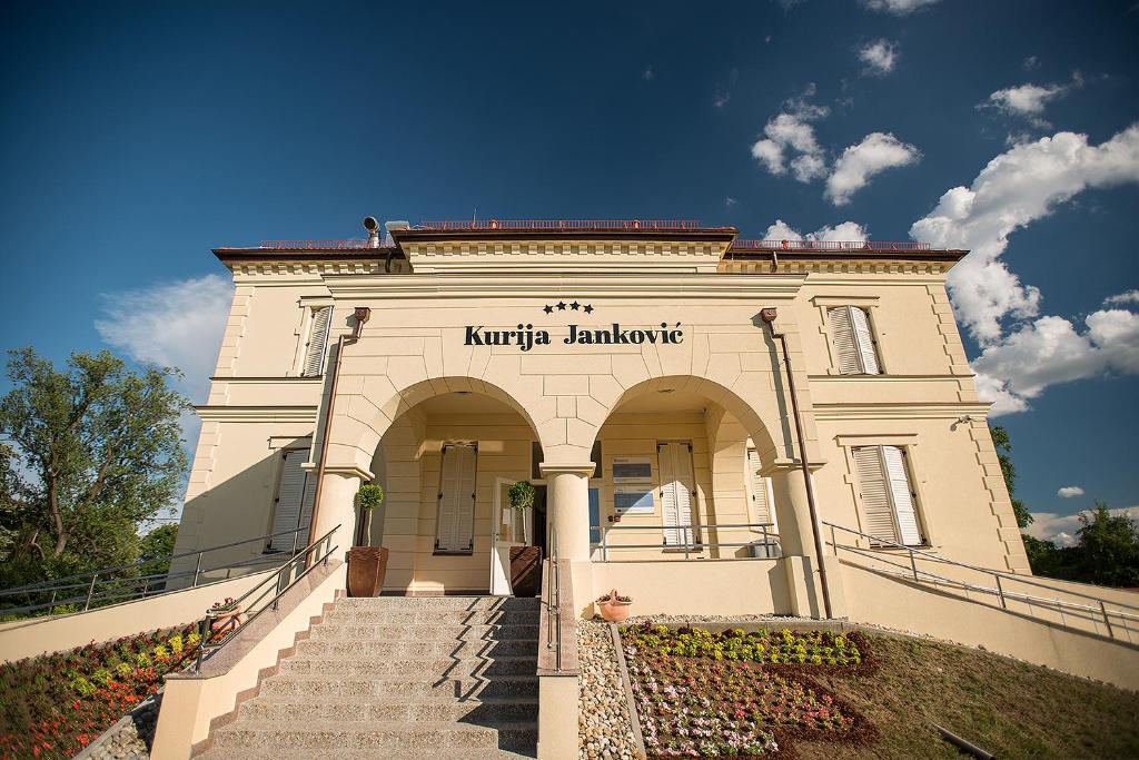 LukačHotel Kurija Janković的白色的建筑,设有通往入口的楼梯