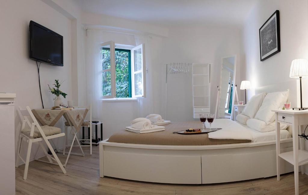 斯普利特马里尼斯公寓的白色的客房设有沙发、桌子和椅子