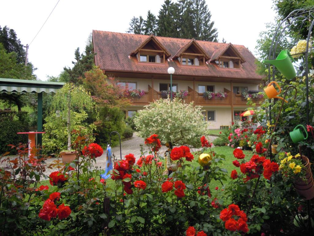 WiesGästehaus Zur schönen Aussicht的一座花园,在房子前种有红色花卉