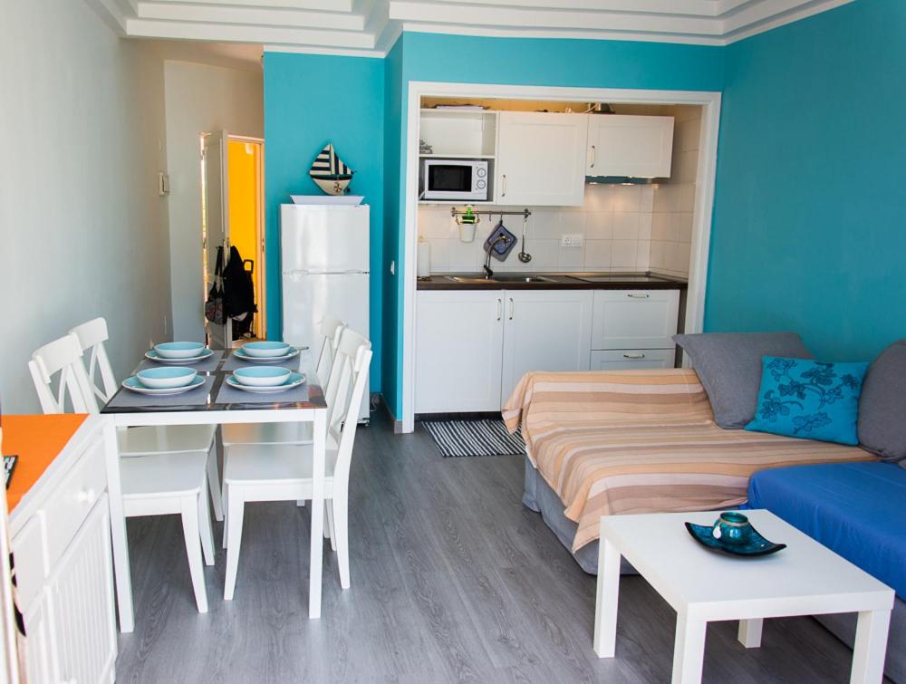阿德耶普拉亚托维斯卡斯公寓的带沙发和桌子的客厅以及厨房。