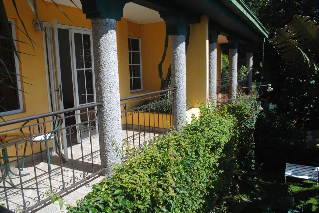 圣萨尔瓦多Apart Hotel Valle Verde的黄色房子,门廊上有一柱子