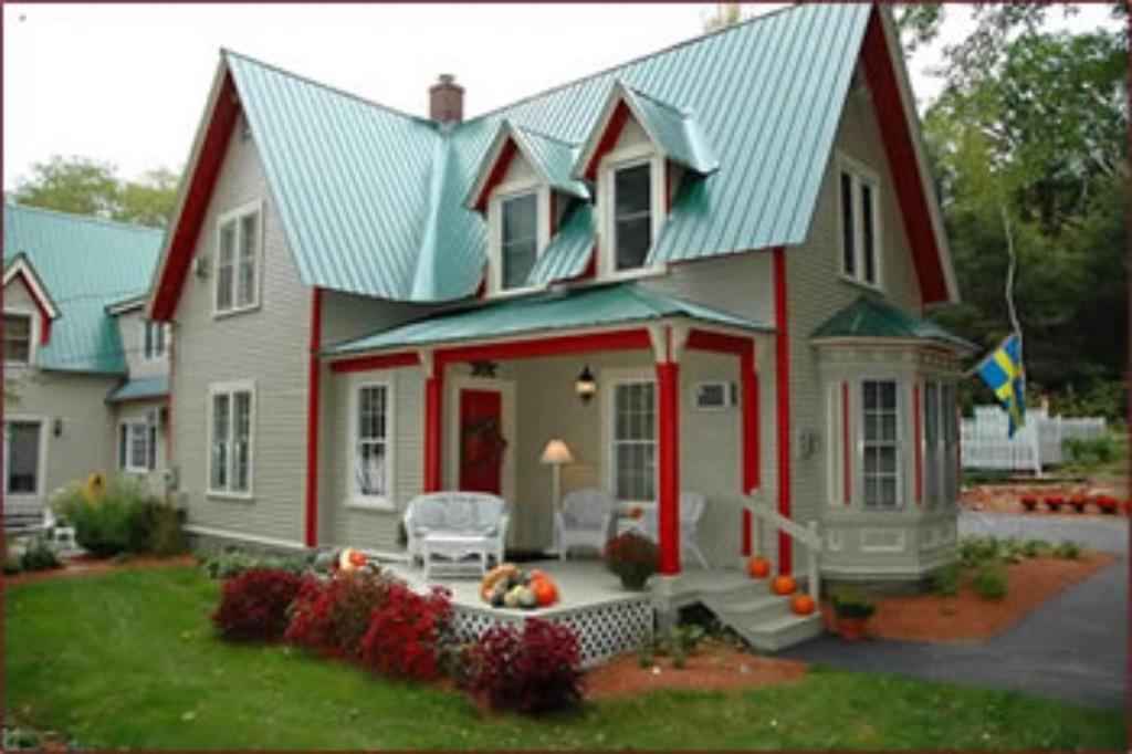 北康威红色大象住宿加早餐旅馆的红白色房子,有绿色屋顶