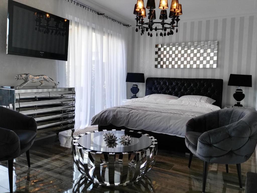 乌斯特卡Apartamenty De Soleil的一间卧室配有一张床、两把椅子和一张桌子