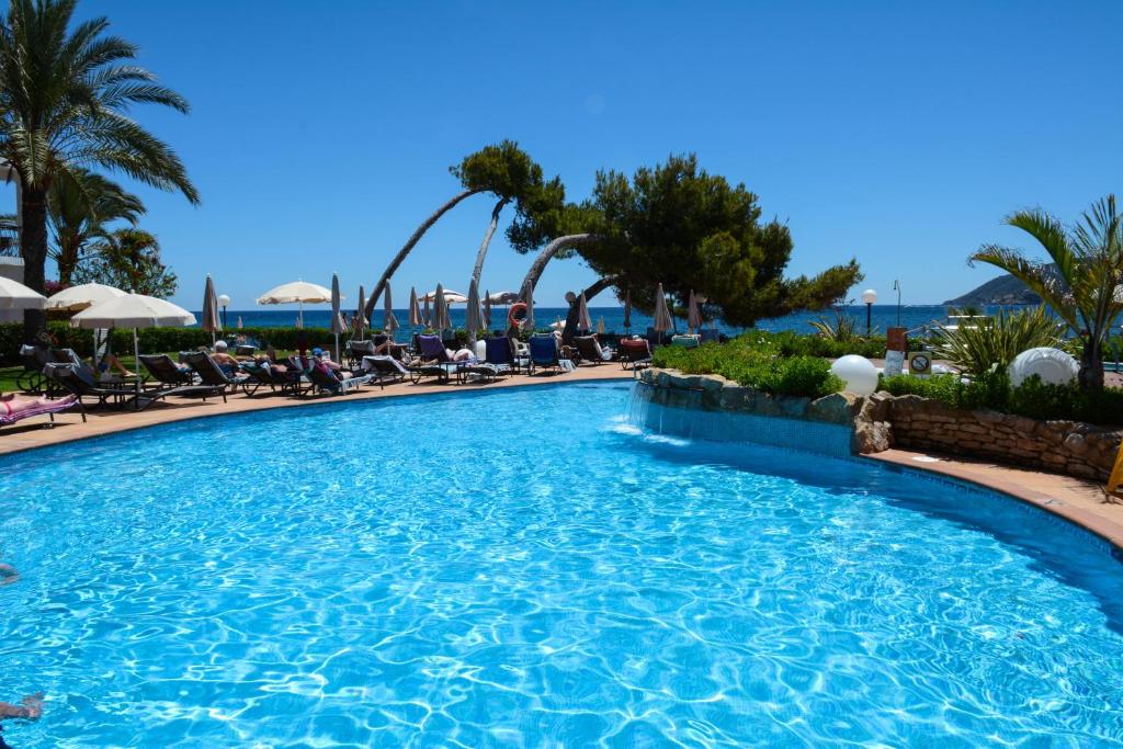 圣埃乌拉利亚加泰罗尼亚瑟斯埃斯塔奎斯酒店 - 仅限成人的棕榈树和椅子的度假村的游泳池