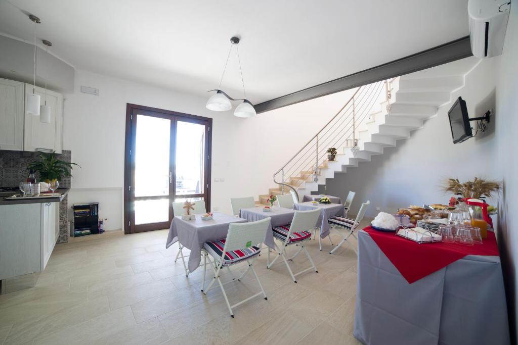 特拉帕尼拉祖迪萨利住宿加早餐旅馆的一间带桌椅的用餐室和楼梯