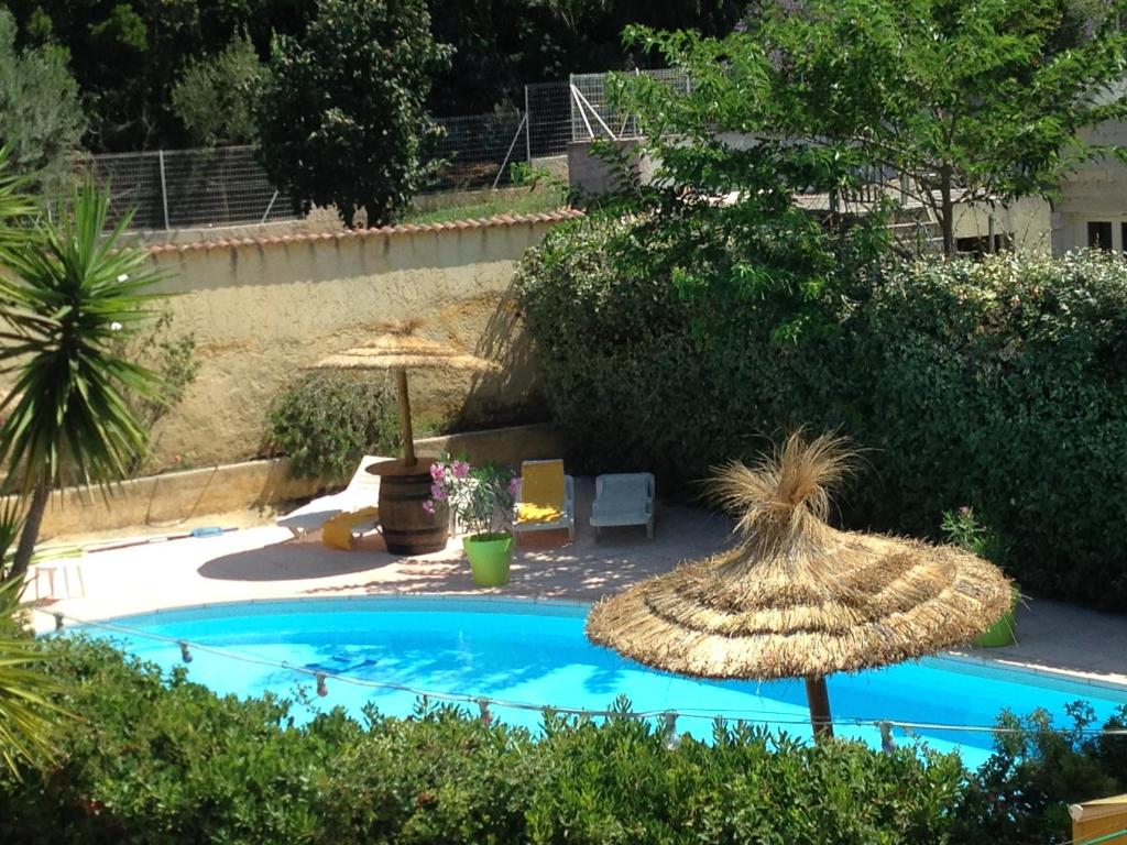 博尔马斯·莱斯·米默萨斯莱斯米默萨斯酒店的两个稻草遮阳伞坐在游泳池旁