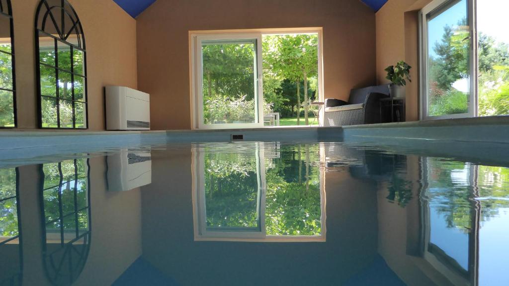 艾瓦耶La Couette de l'Ours的一座房子,在窗户的房间里设有游泳池