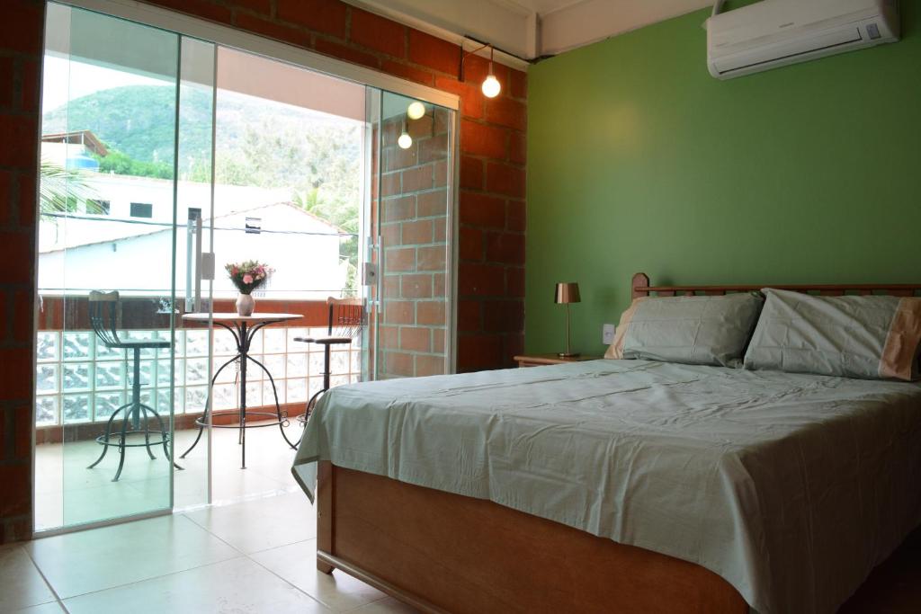 里约热内卢马拉维拉旅馆的一间卧室设有一张床和绿色的墙壁