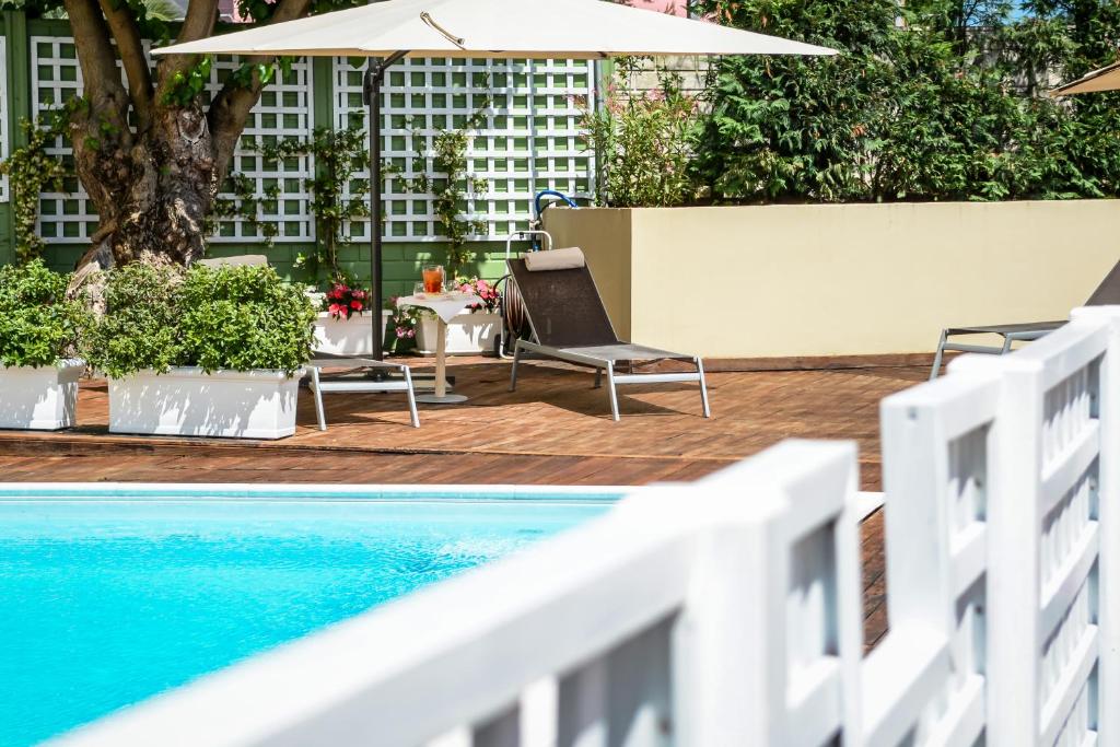 卡梅拉诺康科德酒店的一个带椅子和遮阳伞的游泳池