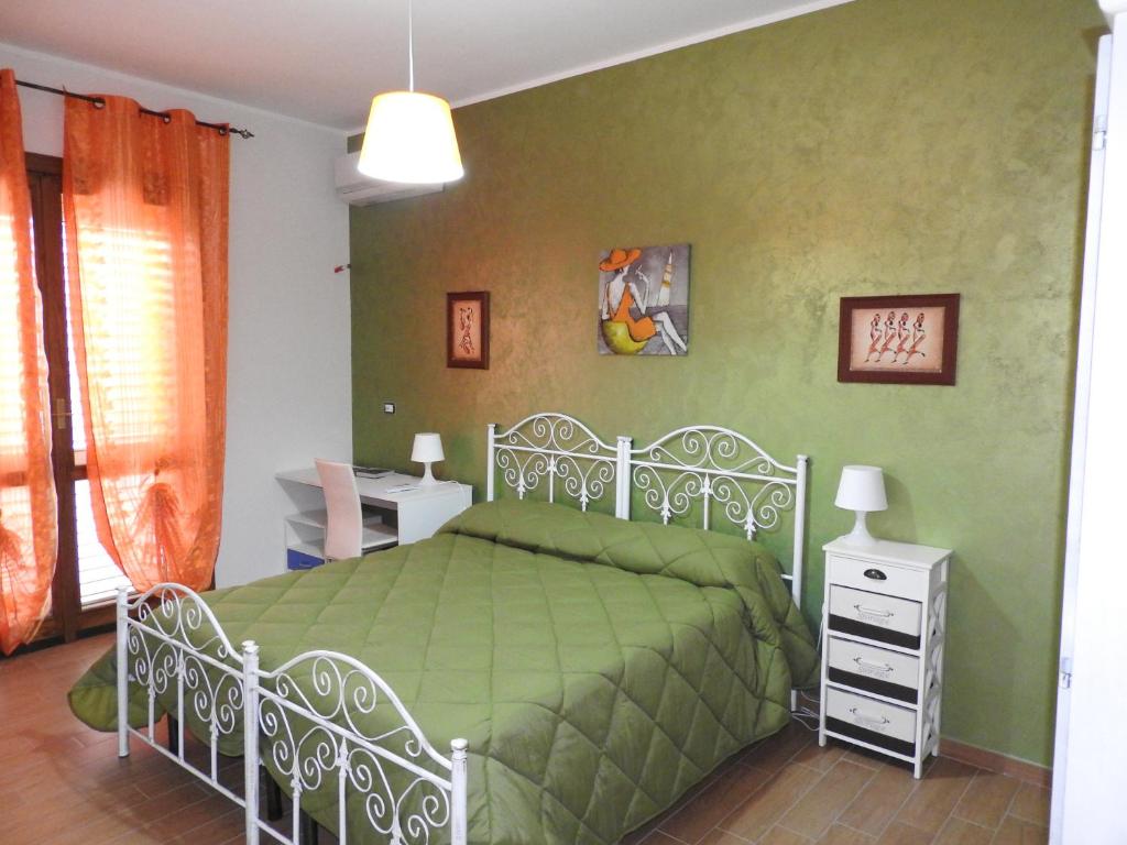 莱韦拉诺B&B la Coccinella的一间卧室配有一张带绿床罩的床