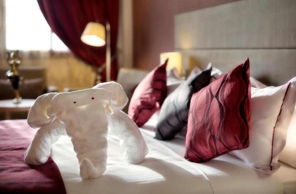 瓦加杜古Bravia Hotel Ouagadougou的一只塞满了大象的睡床上,床上放着枕头