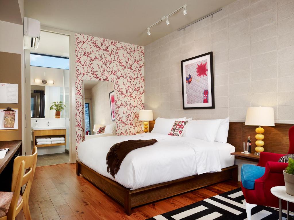奥斯汀海伍德酒店的卧室配有白色的床和红色及白色的墙壁