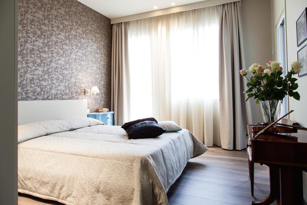 莫利亚诺威尼托阿拉麦塔住宿加早餐旅馆的一间卧室,配有一张床和花瓶