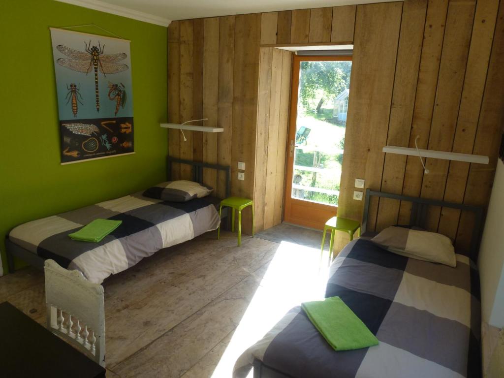 BiertLes Deux Vélos Chambres d'Hotes-Table d'Hotes的配有两张床的客房,设有绿色的墙壁和窗户