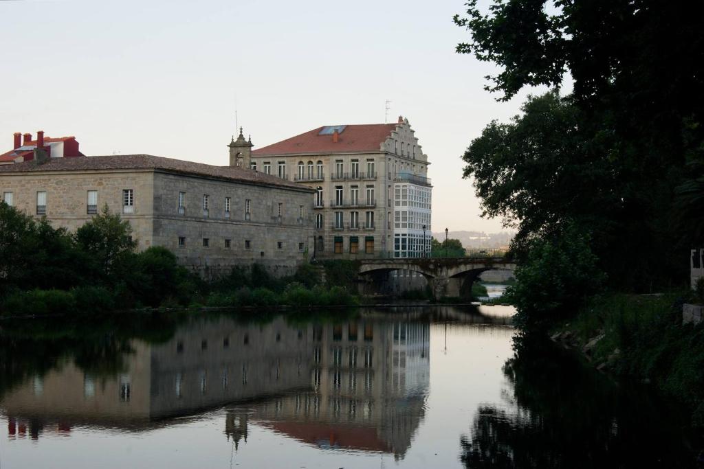卡尔达斯·德·雷斯巴尔内阿里奥坎阿库纳酒店的享有河流美景,设有建筑和桥梁