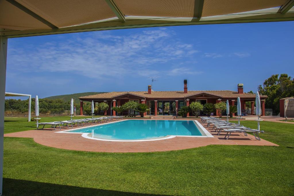 圣塔·马里亚·迪·帕尔玛Villa Barbarina Nature Resort的一个带椅子的游泳池以及一座房子