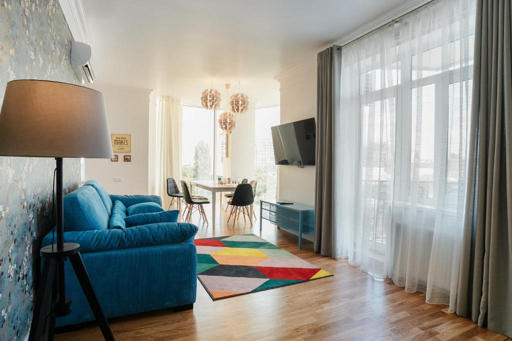 敖德萨Royal Flowers Apartments的客厅配有蓝色的沙发和桌子