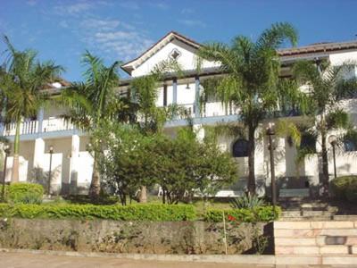 马里亚纳普罗维登西亚酒店的一座大型白色房子,前面有棕榈树