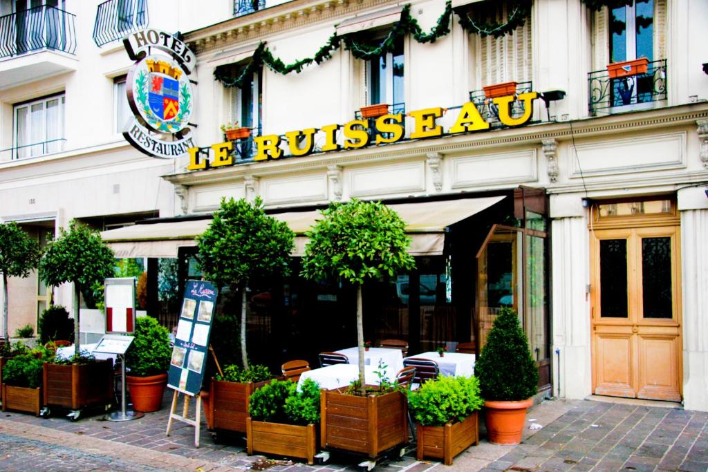 圣芒代路易索酒店的楼前有盆栽植物的餐厅