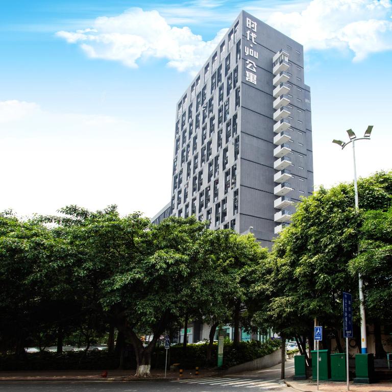 广州诺盟国际公寓广州先烈南路时代国际YOU店的前面有树木的高楼