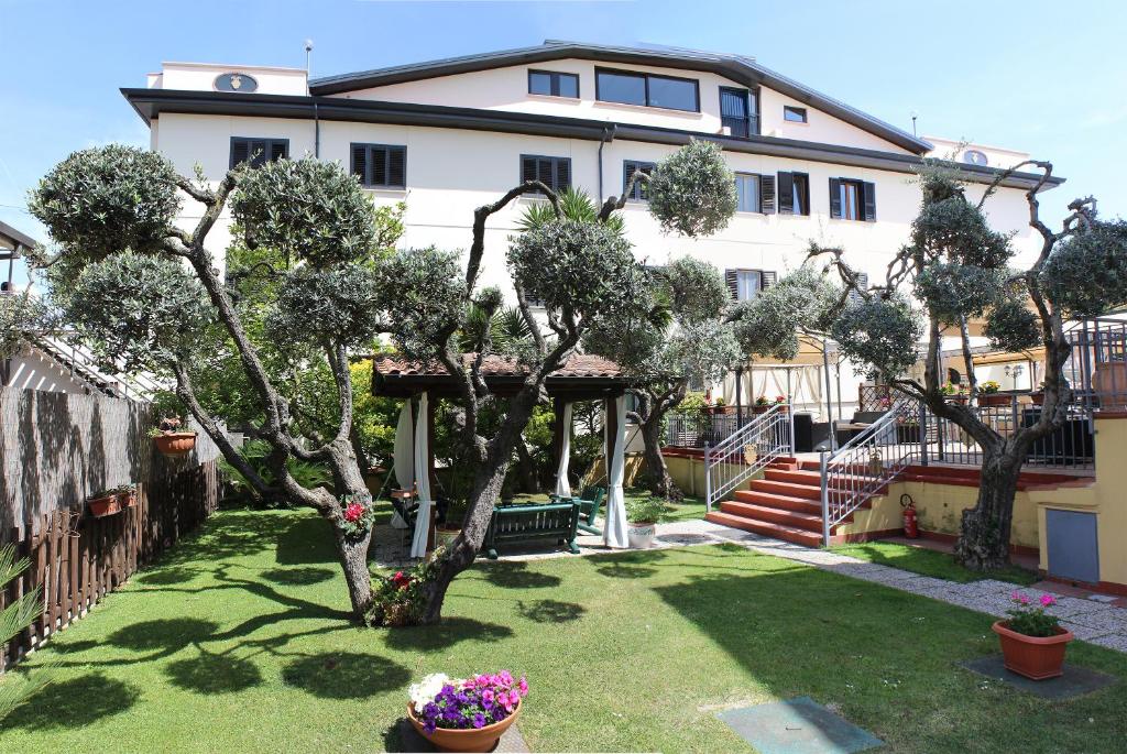 Lariano奈斯波罗多罗酒店的一座有树木和鲜花的院子的房子
