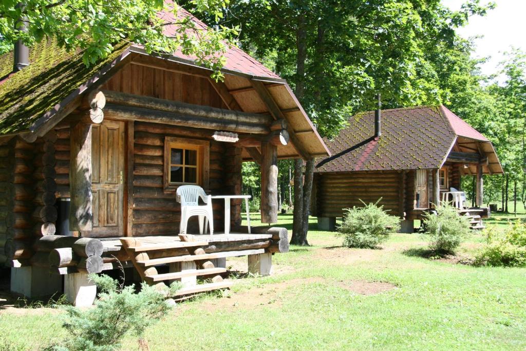 Ķegums斯聂德斯野营地的小木屋前方设有桌椅