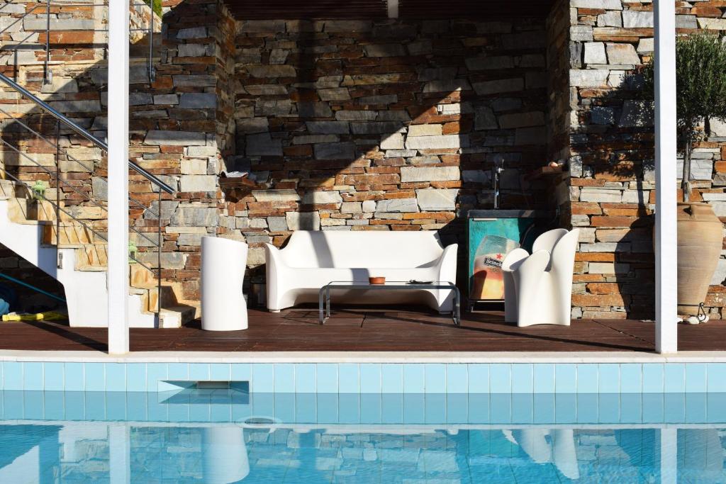 雅典全景顶层公寓的砖墙旁的白色家具游泳池