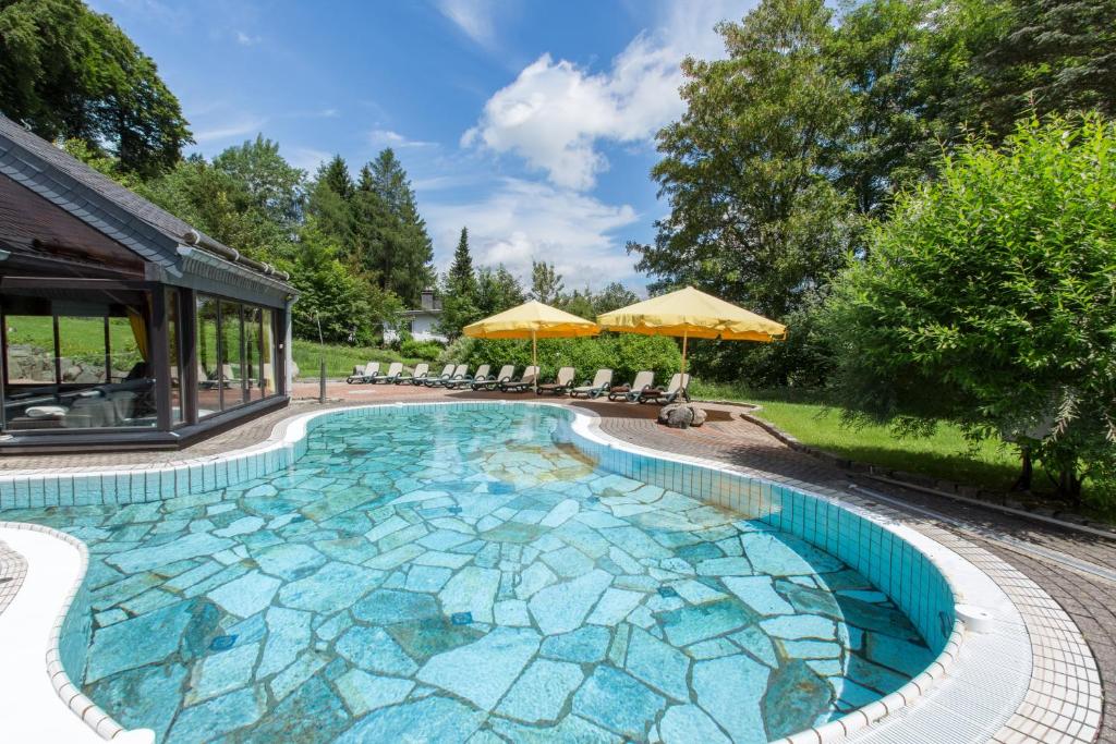 维林根斯特里克豪斯罗曼蒂克酒店的庭院内的大型游泳池,拥有蓝色马赛克装饰
