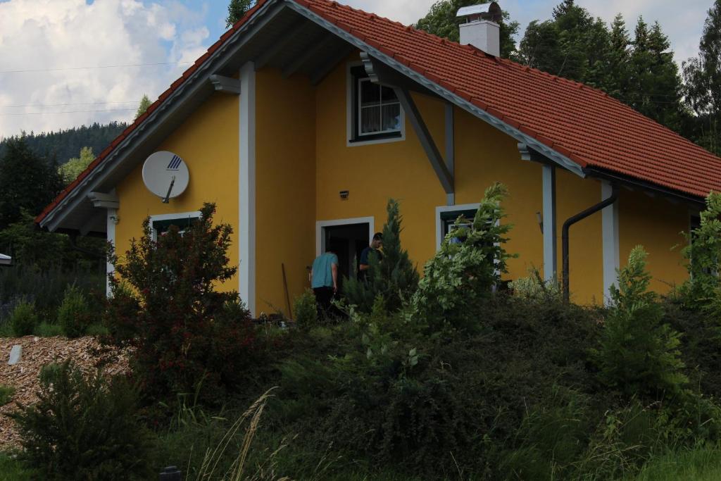 Schwarzenberg am BohmerwaldFerienhaus Grobauer的黄色的房屋,有红色的屋顶