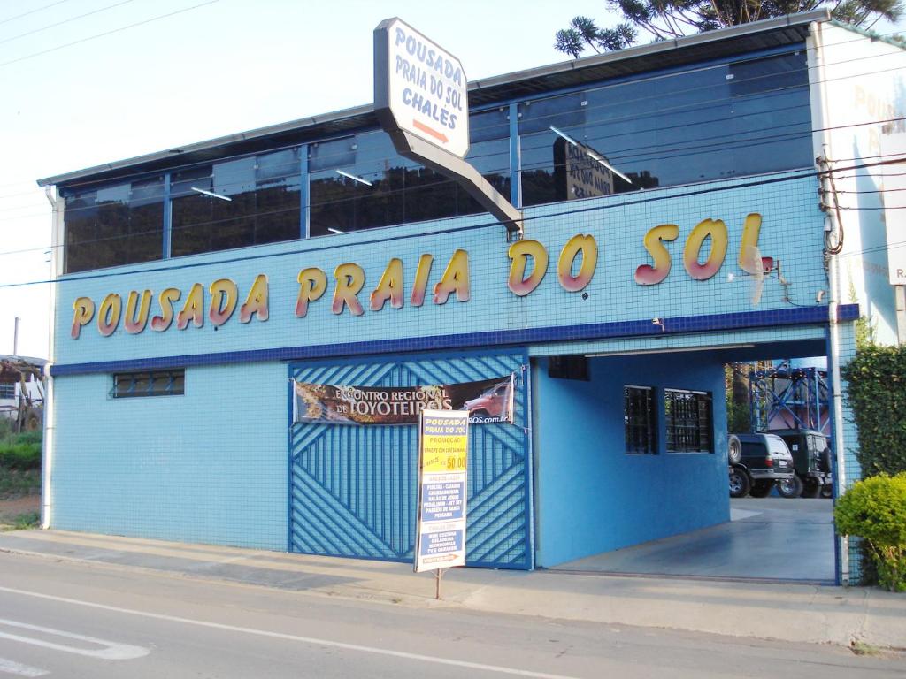 波苏斯-迪卡尔达斯普莱亚索尔旅馆的一座蓝色的建筑,上面有读Poulada praça do son的标志