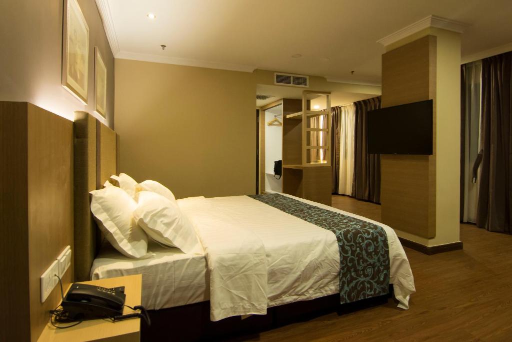 居銮Hotel Anika Kluang的酒店客房,配有床和电视