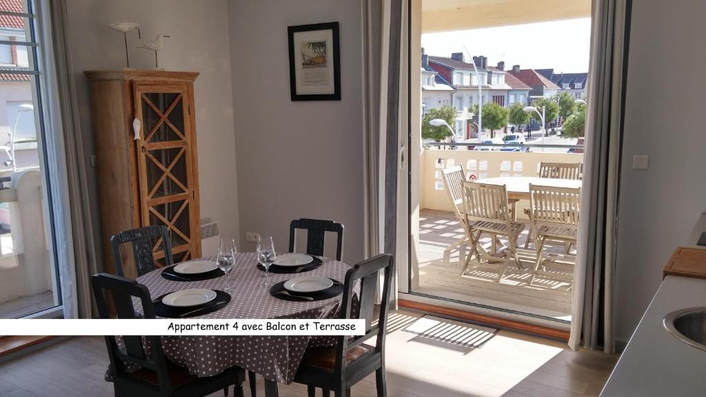 马翁普拉日堡VILLA CHANTEREINE - apparts à 5 mn de la plage - BAIE DE SOMME的一间带桌椅的用餐室和一个阳台