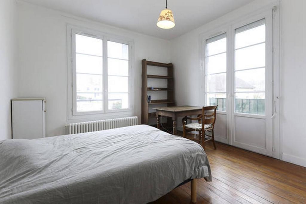 克雷伊Chambres meublées chez l'habitant dans appartement proche gare sncf的卧室配有一张床、一张书桌和窗户。