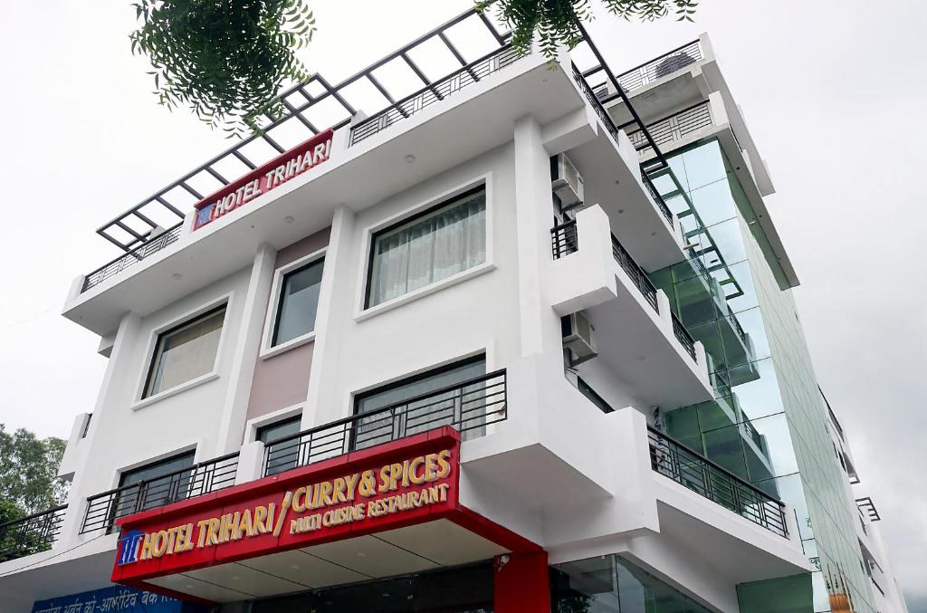瑞诗凯诗Hotel Trihari的白色的建筑,上面有红色的标志