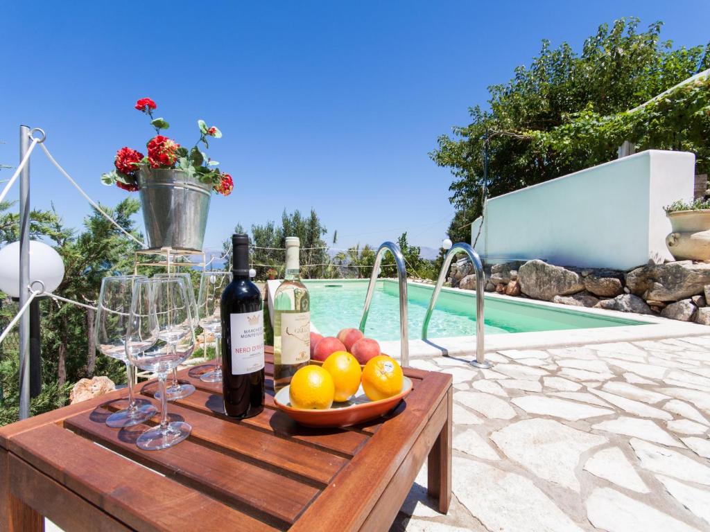 卡斯泰拉马莱Villa Antico Pozzo piscina privata SPA的一张桌子,旁边是酒杯和水果