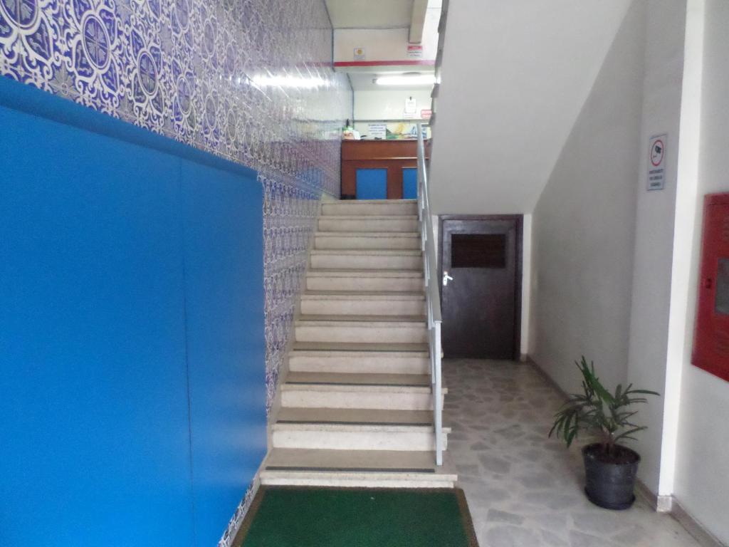 库里提巴Hotel Lisboa的一栋带蓝色墙壁的办公大楼内的楼梯