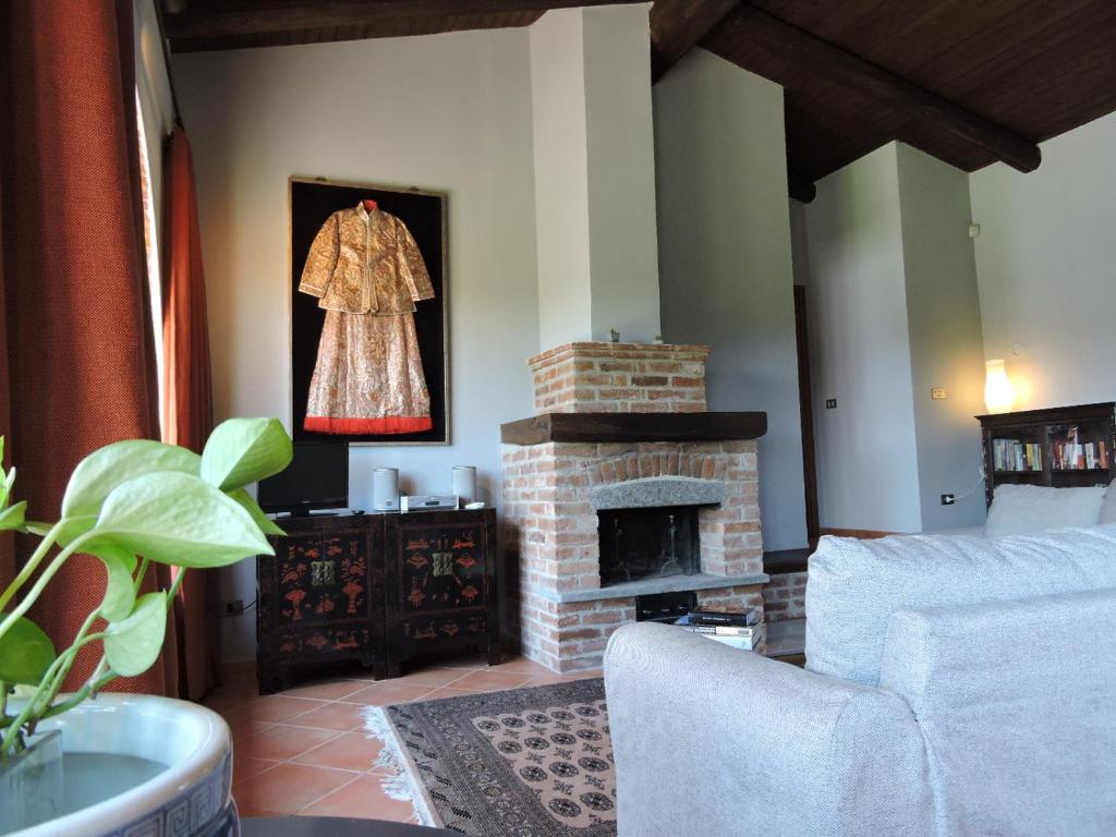 Case BruciateCascina Volpona的客厅设有壁炉和挂在墙上的连衣裙