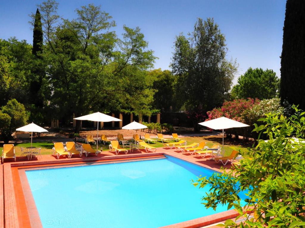 阿尔维图卡斯特洛阿尔维托酒店的一个带躺椅和遮阳伞的游泳池
