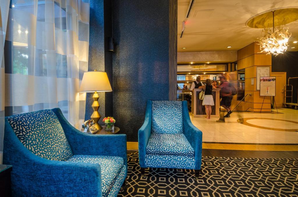 华盛顿毕考酒店及公司宿舍的大堂的两把蓝色椅子,走廊里的人